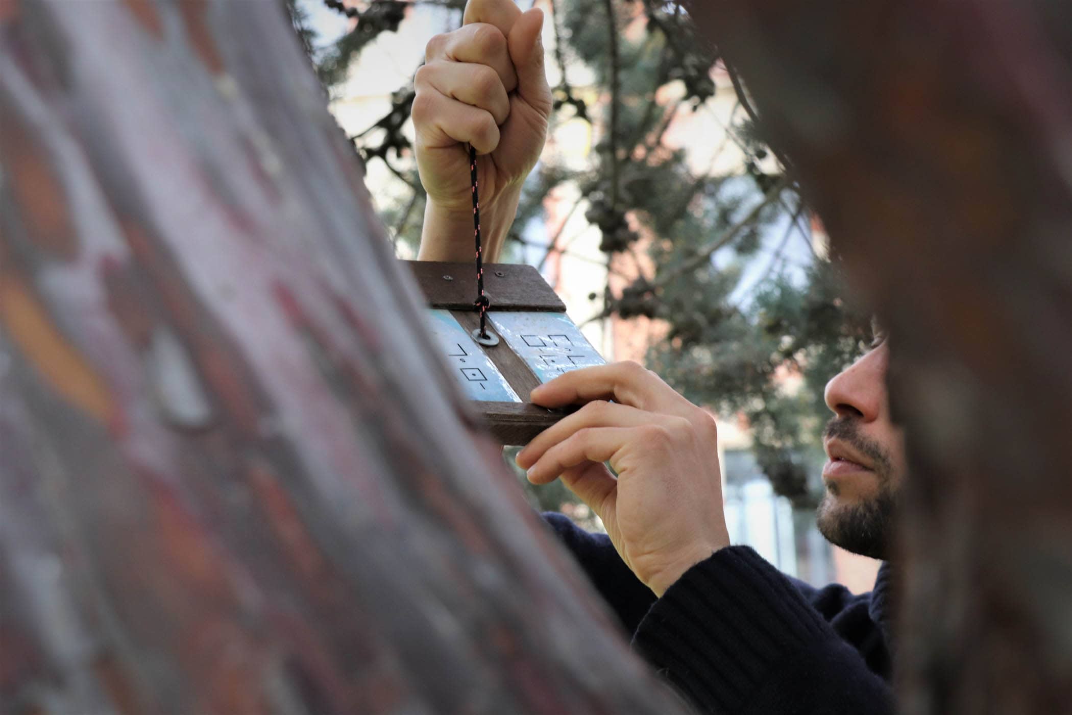 Un participant déchiffre un code caché dans un arbre lors d'un séminaire RSE organisé dans le parc du château de Nanterre