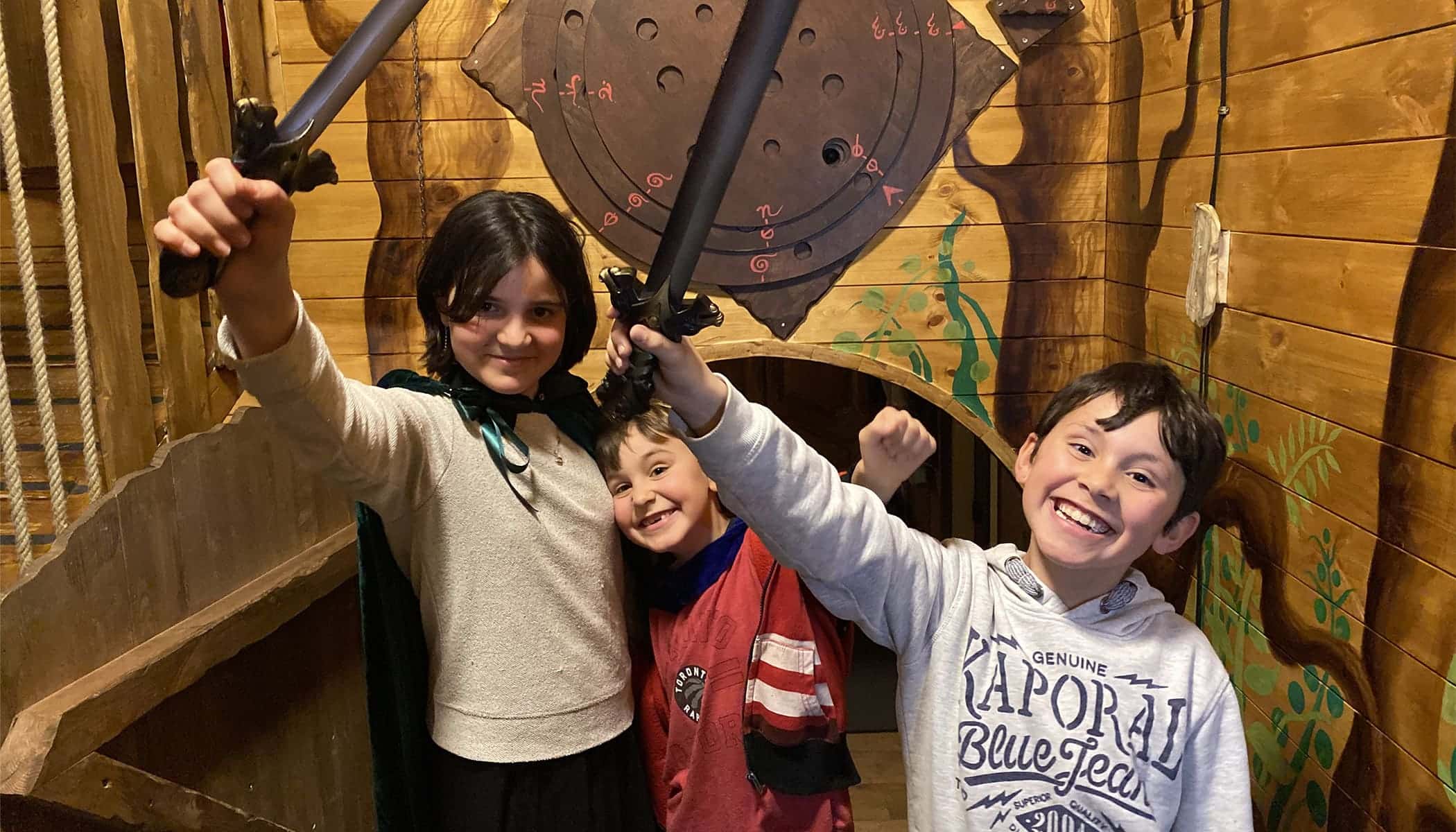 3 enfants de moins de 12 ans posent fièrement devant l'appareil photo après leur victoire lors d'un escape game inspiré du Seigneur des Anneaux