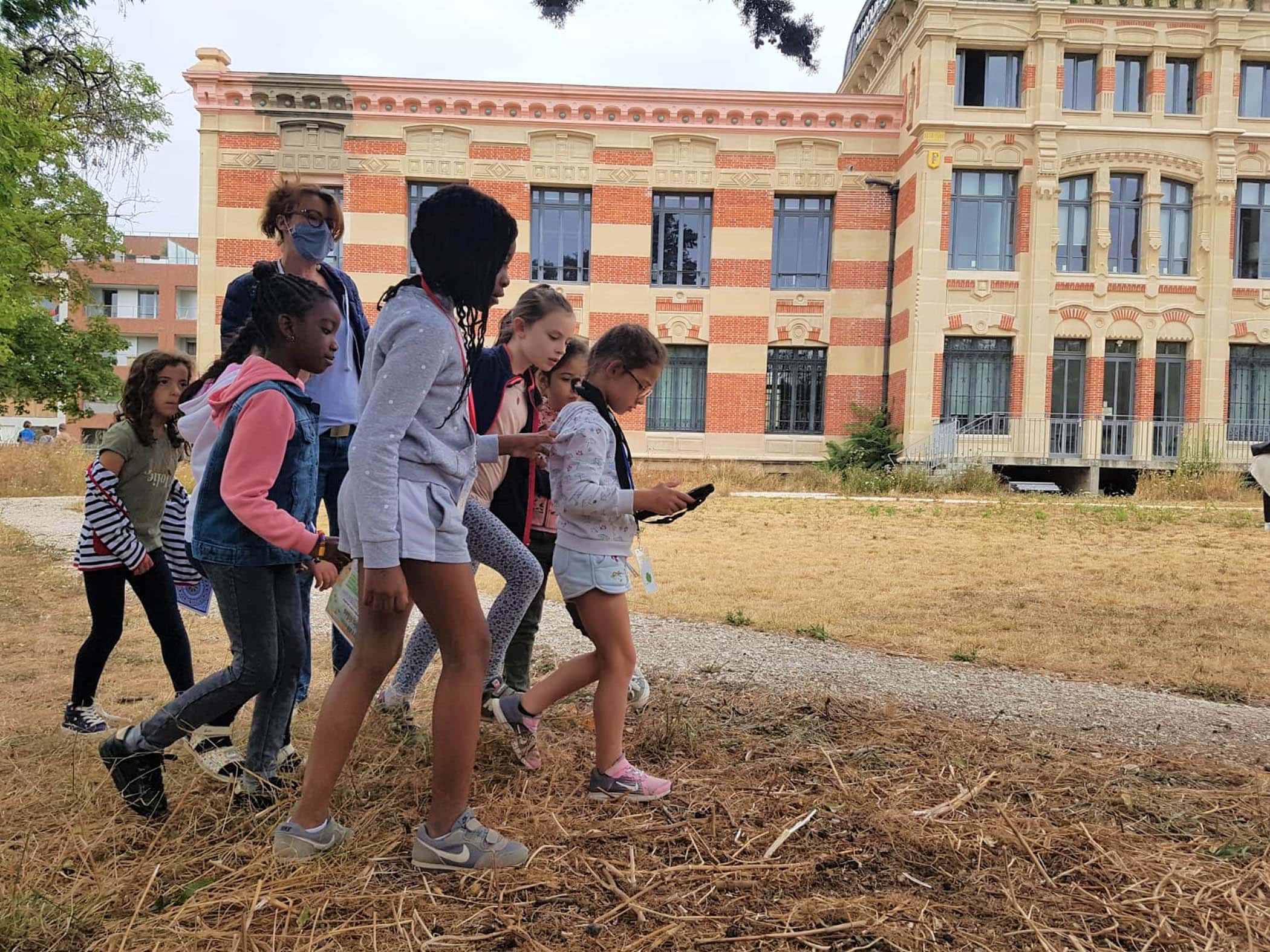 De jeunes joueurs et joueuses explorent le Parc du Château de Nanterre lors d'une activité ludique organisé pour un anniversaire