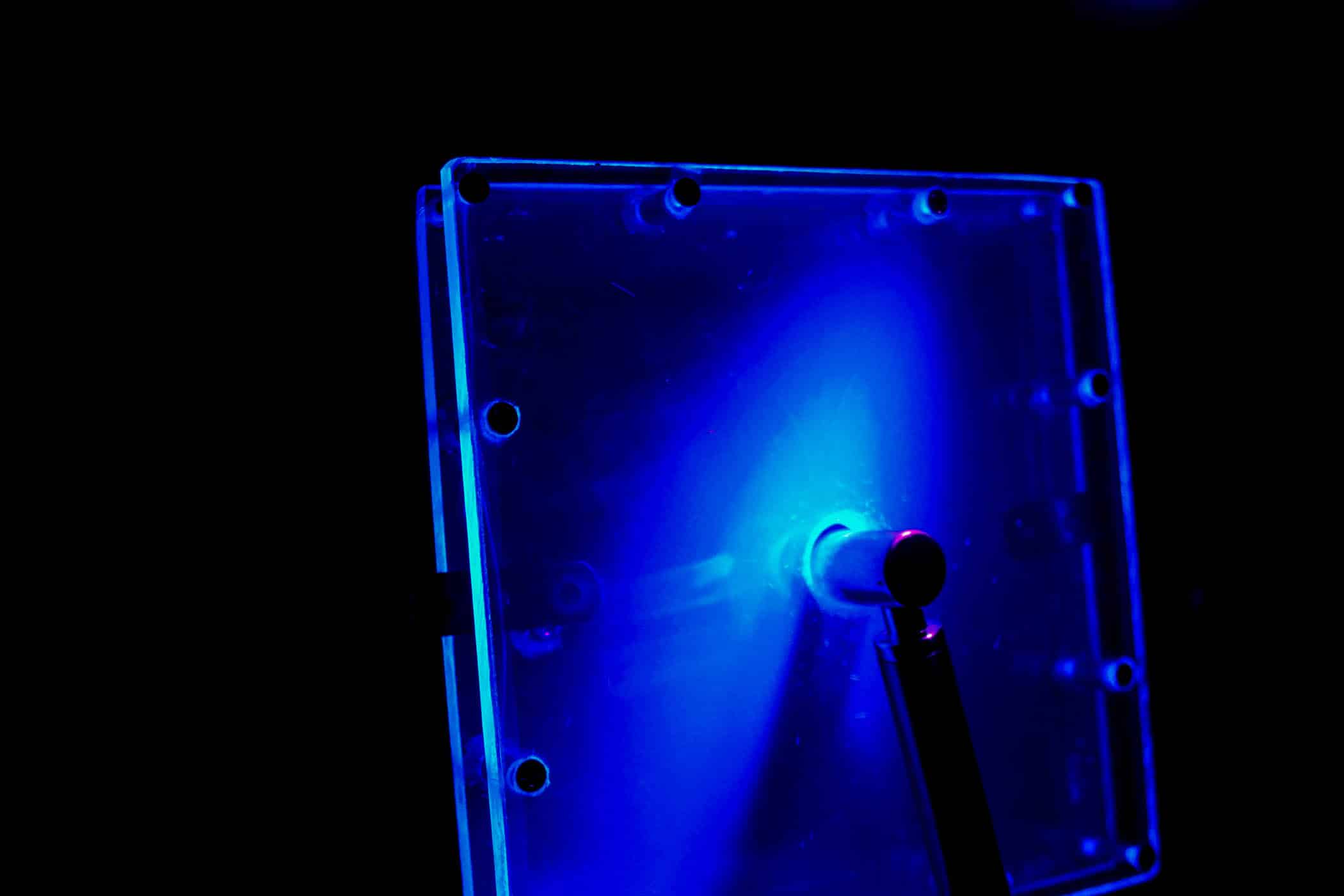 Photo d'une boîte contenant un liquide mystérieux et masqué par une lumière bleu