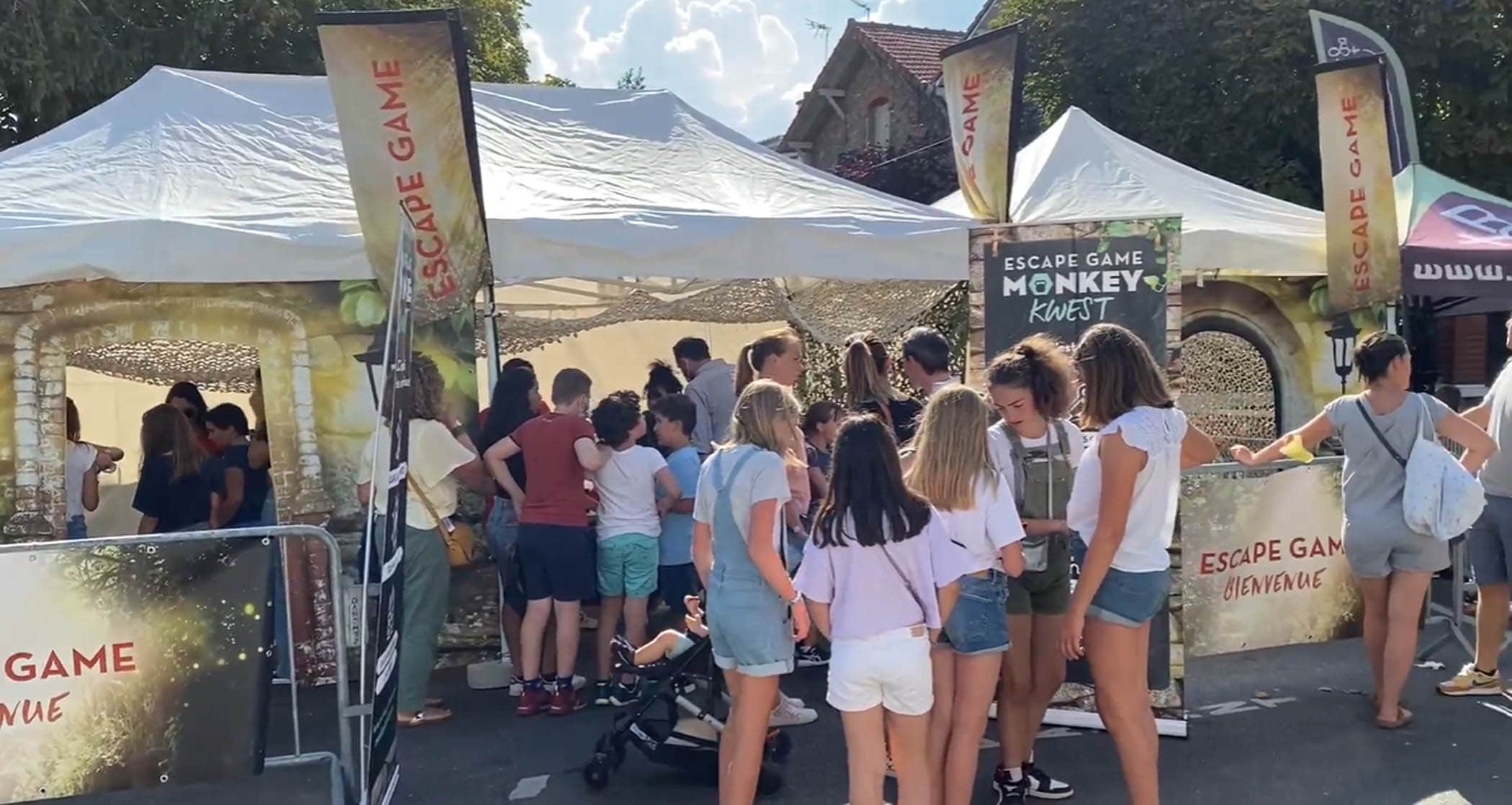 Plusieurs familles patientent devant le stand de Monkey Kwest, un escape game outdoor spécialement organisé pour la fête de la Ville à Garches