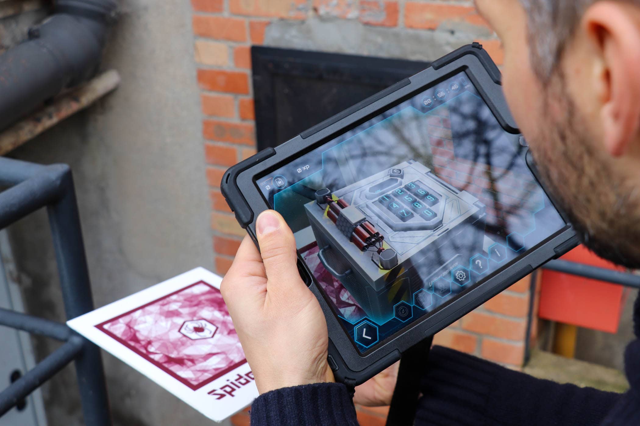 Une énigme apparait en 3D sur une tablette numérique pendant que le joueur vise un objet avec cette dernière
