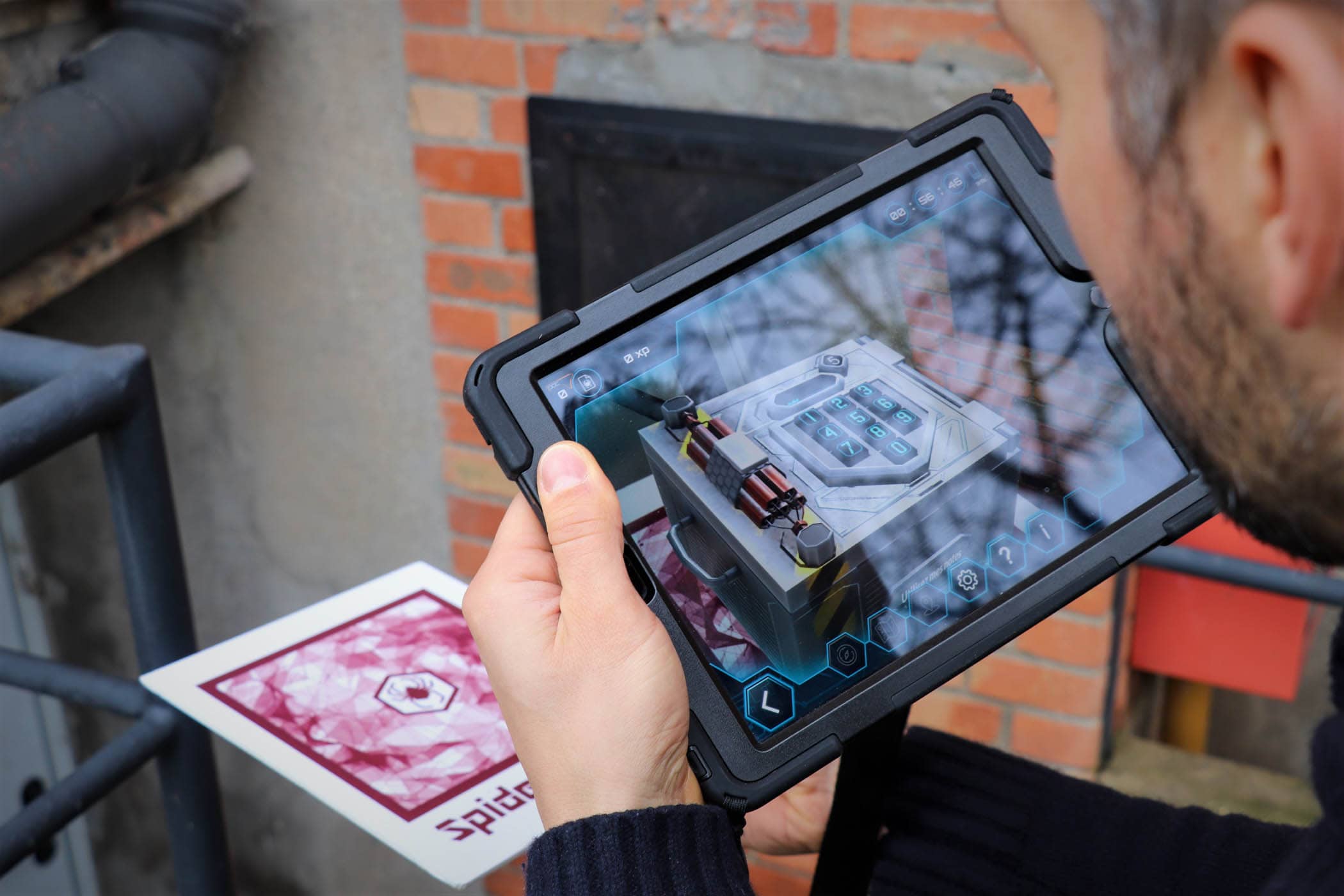 Escape Game – Opération Greenfinger Un coffre 3D apparaît sur une tablette lorsque le joueur pointe sa tablette sur un objet qu'il tient en main