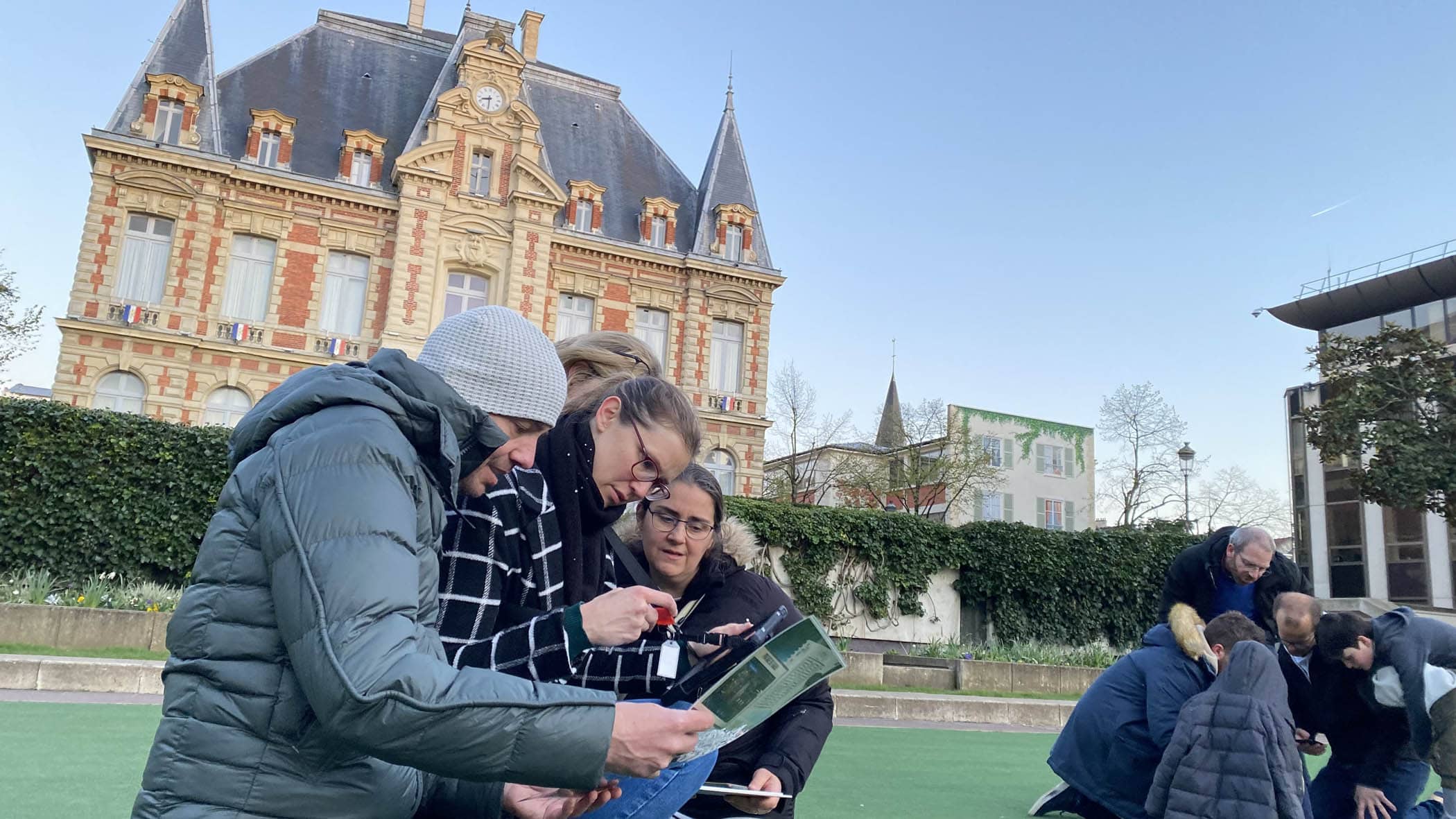 Une équipe de joueurs résout une énigme sue l'esplanade de l'Hôtel de ville de Rueil-Malmaison